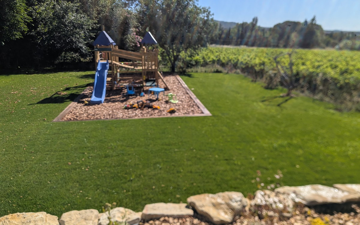 Le même jardin terminé : pelouse dense et aire de jeux paillée